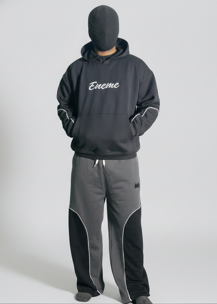 Person wearing a gray tracksuit with 'ENEME' branding on a white background
